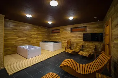 a bathroom with a tub and a sink and chairs at Ranch Jestřebice in Heřmaničky