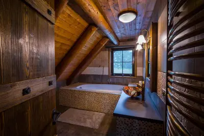 a large bathroom with a tub in a wooden ceiling at Ranch Jestřebice in Heřmaničky