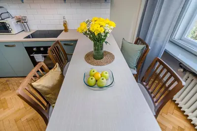 a table with a bowl of fruit and a vase of flowers at APT IN CENTER Prague Great view by Michal&Friends in Prague