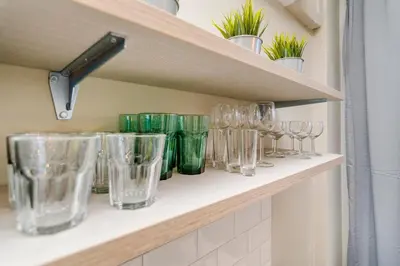 a row of glasses on a shelf with plants at APT IN CENTER Prague Great view by Michal&Friends in Prague