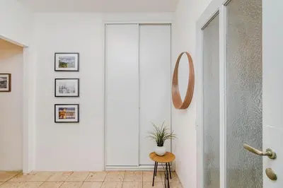 a white hallway with a potted plant on a stool at APT IN CENTER Prague Great view by Michal&Friends in Prague