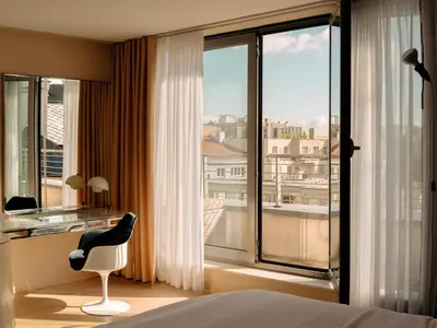 a bedroom with a bed and a chair and a window at Hotel Josef in Prague