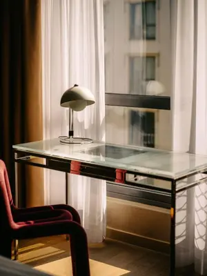 a glass desk with a lamp on it next to a window at Hotel Josef in Prague