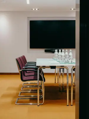 a dining room with a table with chairs and a flat screen tv at Hotel Josef in Prague