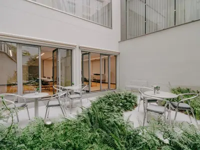 a patio with tables and chairs in a building at Hotel Josef in Prague