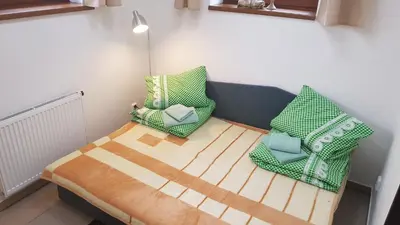 a small room with a bed and two pillows at Na samotě u lesa -Rasovna in Mšecké Žehrovice