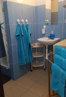 a blue bathroom with a sink and blue towels at Na samotě u lesa -Rasovna in Mšecké Žehrovice