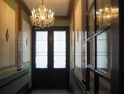 a hallway with a black door and a chandelier at Žatecká - Old Town Residence in Prague