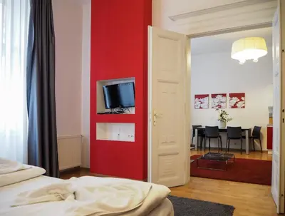 a bedroom with a red wall with a tv on it at Žatecká - Old Town Residence in Prague