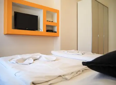 two beds in a room with a tv on the wall at Žatecká - Old Town Residence in Prague