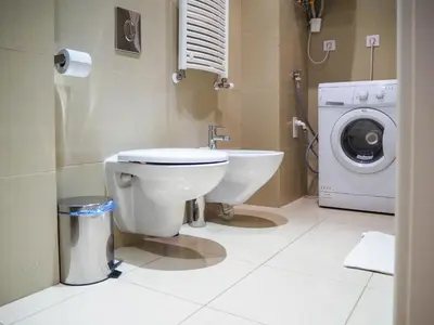 a bathroom with a toilet and a washing machine at Žatecká - Old Town Residence in Prague