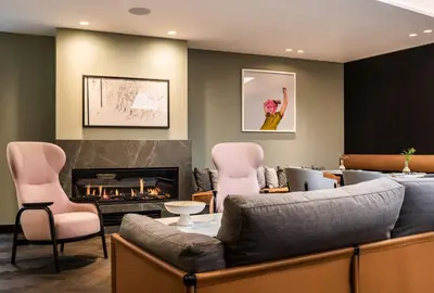 a living room with a couch and chairs and a fireplace at Maximilian Hotel in Prague