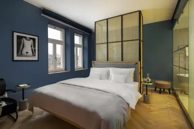 a bedroom with a large bed and a bathroom at Maximilian Hotel in Prague