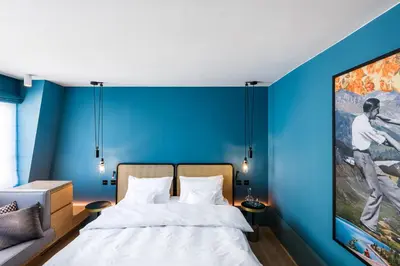 a blue room with a bed and a couch at Maximilian Hotel in Prague