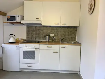 a kitchen with white cabinets and a sink at Apartmán U babičky in Prague