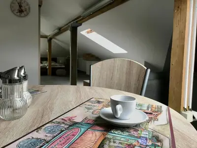 a wooden table with a cup and a plate on it at Apartmán U babičky in Prague