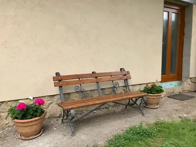 a wooden bench sitting next to two potted plants at Apartmán U babičky in Prague