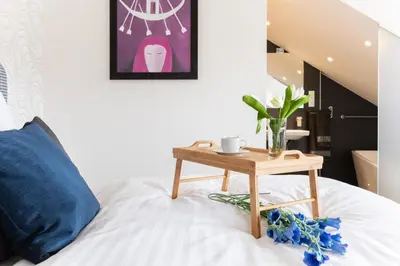 a bed with a wooden table on top of it at Anděl design duplex, AC, garage in Prague