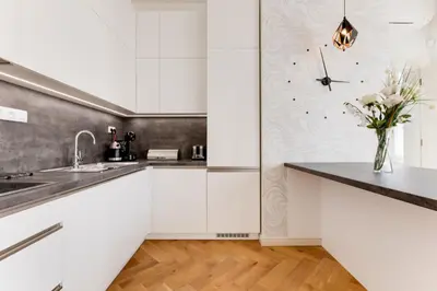 a kitchen with white cabinets and a vase of flowers at Anděl design duplex, AC, garage in Prague