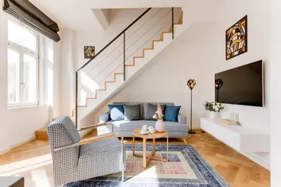 a living room with a couch and a table at Anděl design duplex, AC, garage in Prague