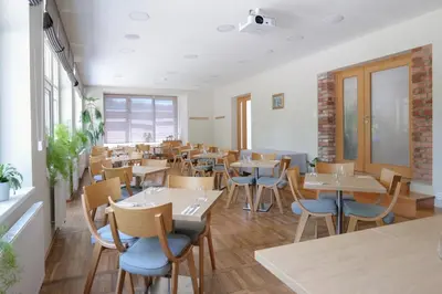 a restaurant with tables and chairs in a room at Penzion Harmony Javorník in Čtyřkoly