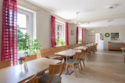 a row of tables in a restaurant with red curtains at Penzion Harmony Javorník in Čtyřkoly