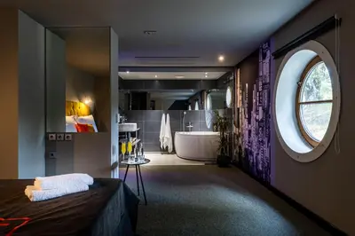 a large bathroom with a tub and a large window at Botel Marina in Prague