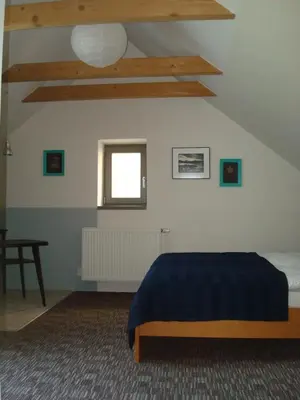 a bedroom with a blue bed and a window at Apartmán pod Velkou Amerikou in Mořina