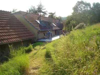 a house sitting on top of a grassy hill at Apartmán pod Velkou Amerikou in Mořina