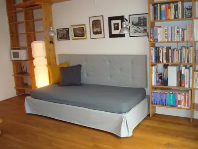 a bed in a room with a book shelf at Apartmán pod Velkou Amerikou in Mořina
