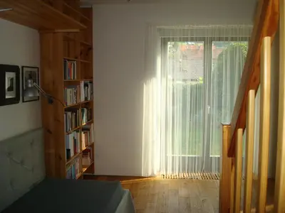 a living room with a window and a book shelf at Apartmán pod Velkou Amerikou in Mořina