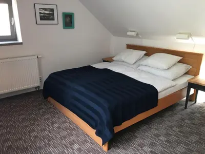 a bedroom with a large bed with two pillows at Apartmán pod Velkou Amerikou in Mořina