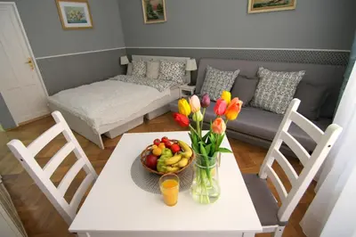 a living room with a table with a bowl of fruit and flowers at ALLSTAR Vinohrady ateliers in Prague