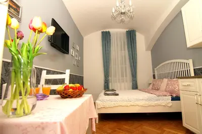 a small room with two beds and a table with flowers at ALLSTAR Vinohrady ateliers in Prague