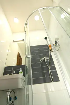 a shower with a glass door next to a sink at ALLSTAR Vinohrady ateliers in Prague