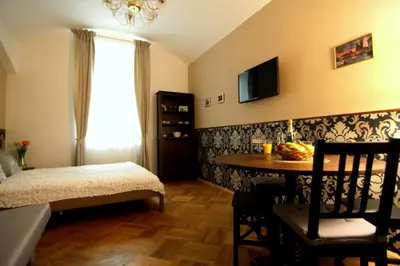 a bedroom with a bed and a table and a television at ALLSTAR Vinohrady ateliers in Prague