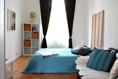 a bedroom with a blue bed and a window at Wellness apartments Karlín in Prague