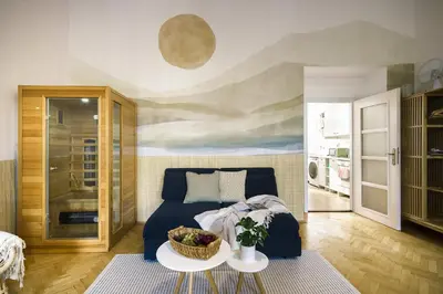 a living room with a blue couch and a table at Wellness apartments Karlín in Prague