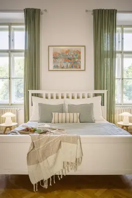 a white bed in a bedroom with windows at Wellness apartments Karlín in Prague