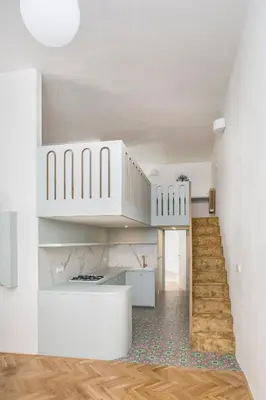 a staircase in a house with white walls and wooden floors at Downtown Designer apartment Karlin in Prague