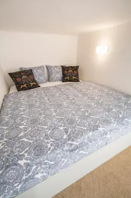 a large bed with a blue and white blanket on it at Downtown Designer apartment Karlin in Prague