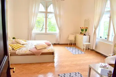 a bedroom with a bed and a dresser and windows at BEDROOM residence with SAUNA in Prague