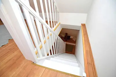 a staircase with white railings and wood floors at Romantic apartment under the Prague castle in Prague