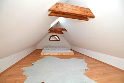 a attic room with a bed and a wooden ceiling at Romantic apartment under the Prague castle in Prague
