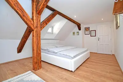 a bedroom with a white bed and wooden beams at Romantic apartment under the Prague castle in Prague