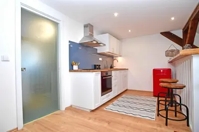 a kitchen with white cabinets and a red refrigerator at Romantic apartment under the Prague castle in Prague