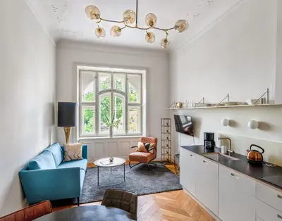 a living room with a blue couch and a table at MN6 Luxury Suites by Adrez in Prague