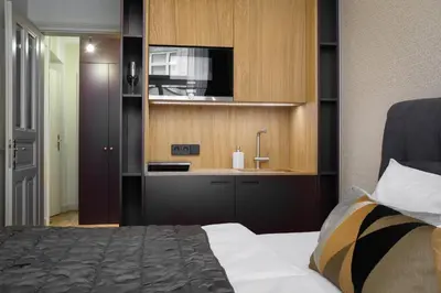 a bedroom with a bed and a sink and a television at MN6 Luxury Suites by Adrez in Prague