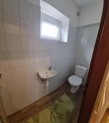 a bathroom with a toilet and a sink and a window at Apartmány Vinařství Klučov in Lstiboř