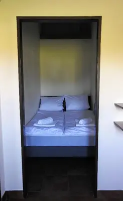a bed with a black cat sitting on top of it at Apartmány Vinařství Klučov in Lstiboř